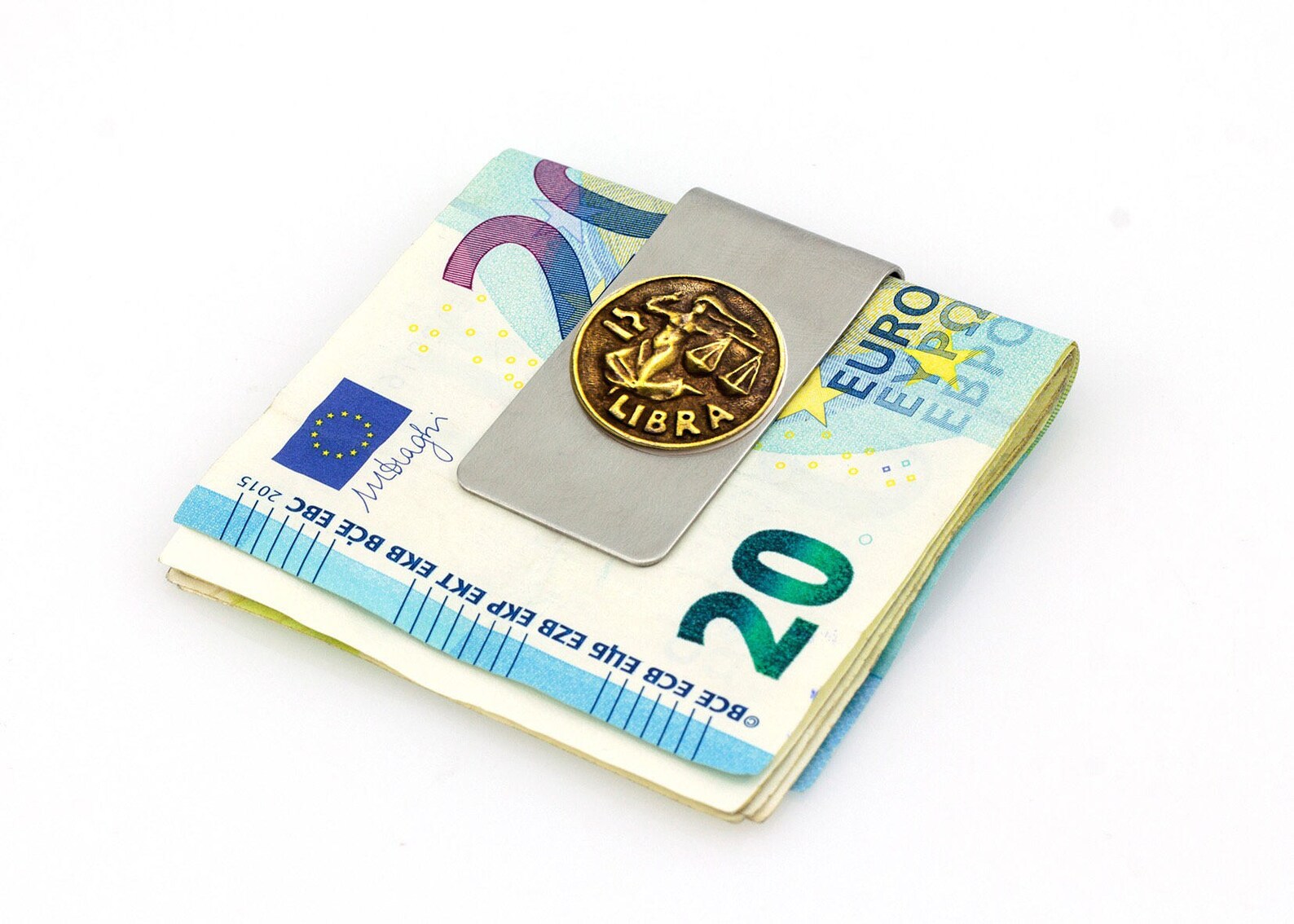 Libra zodiac money clip holding folded euro banknotes.